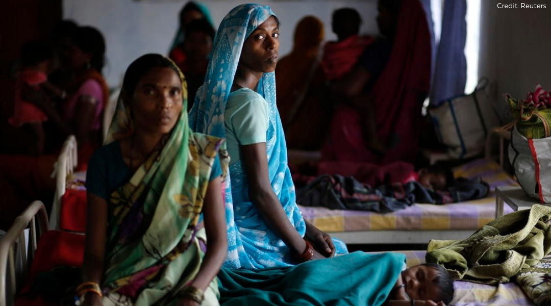 Two women sitting on beds in an primary clinic in rural India