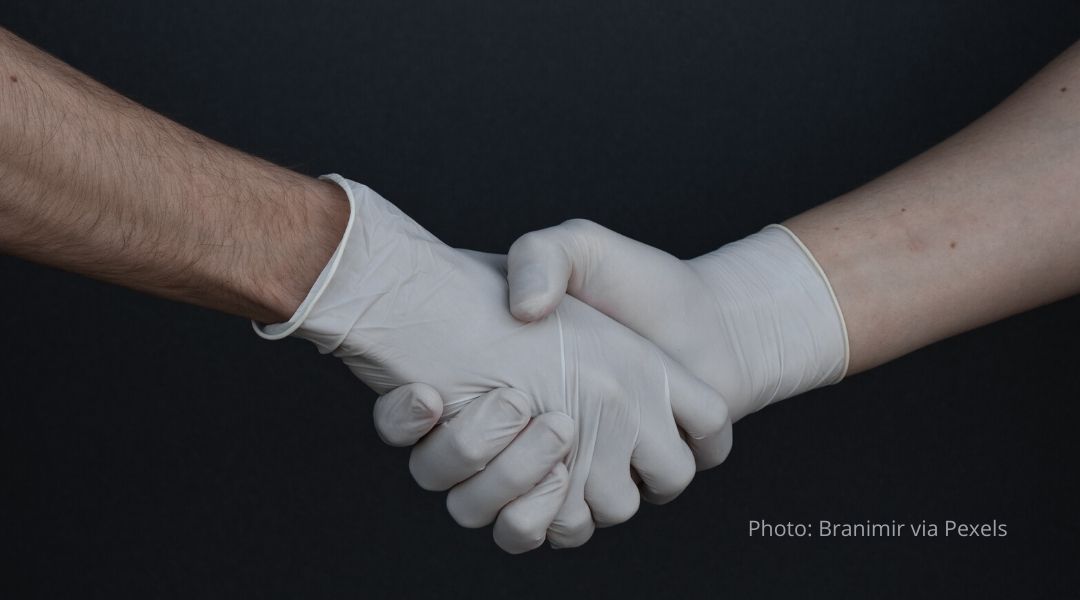 Rubber gloved hands, shaking hands together