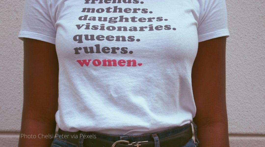 A woman's t-shirt reads. Friends. mothers. daughters. visionaries. queens. rulers. women.