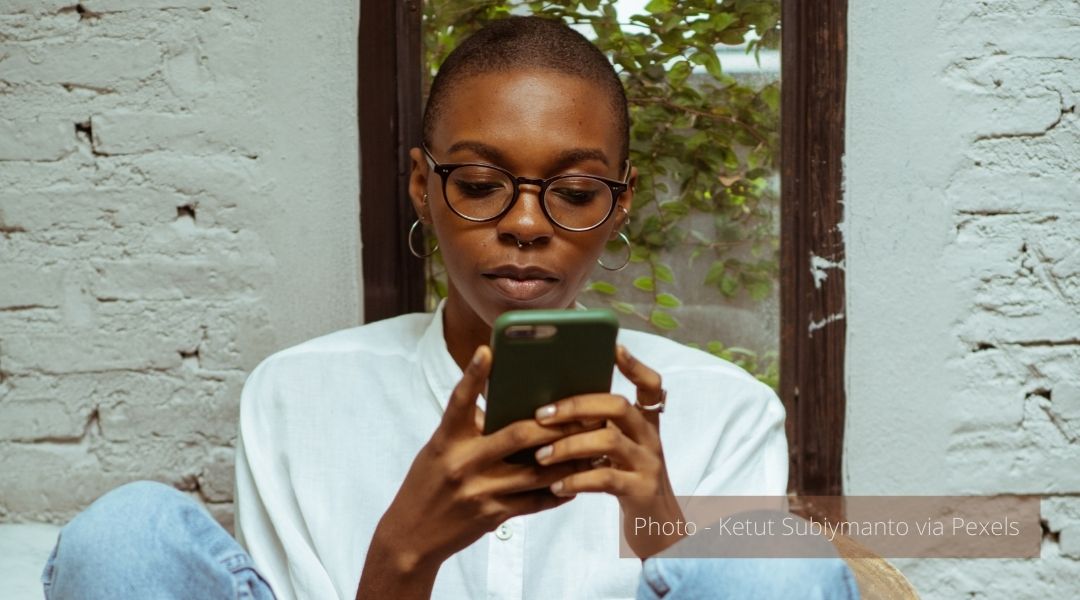A young woman deeply engaged with a smart phone
