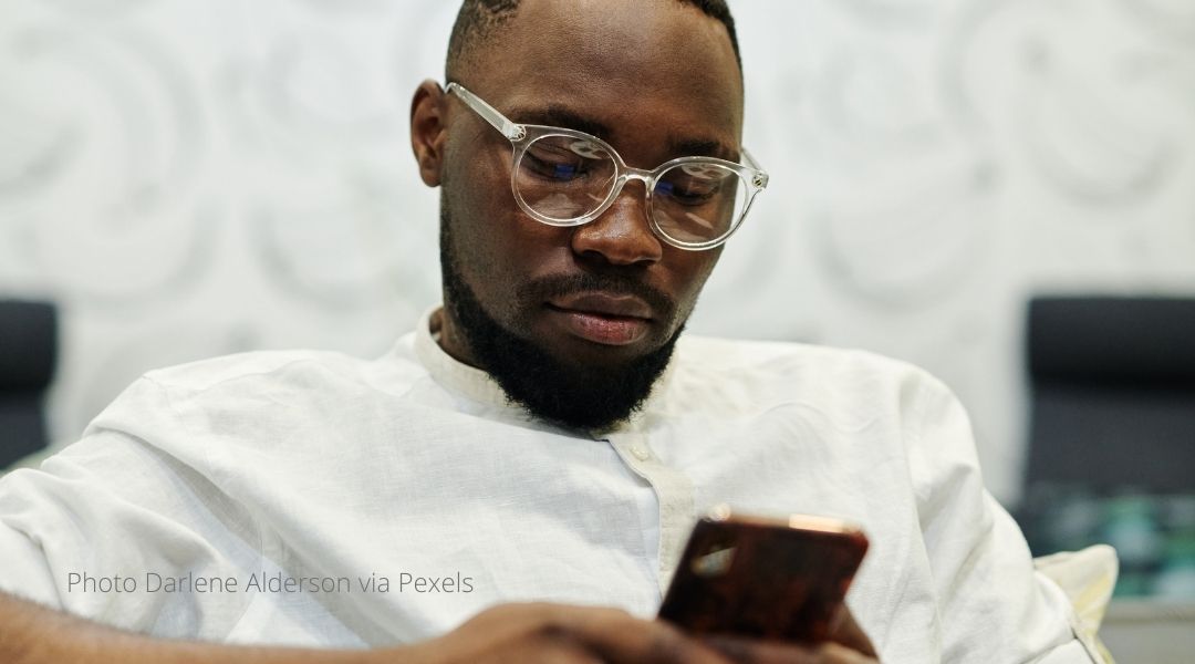 A young man studies his smart-phone