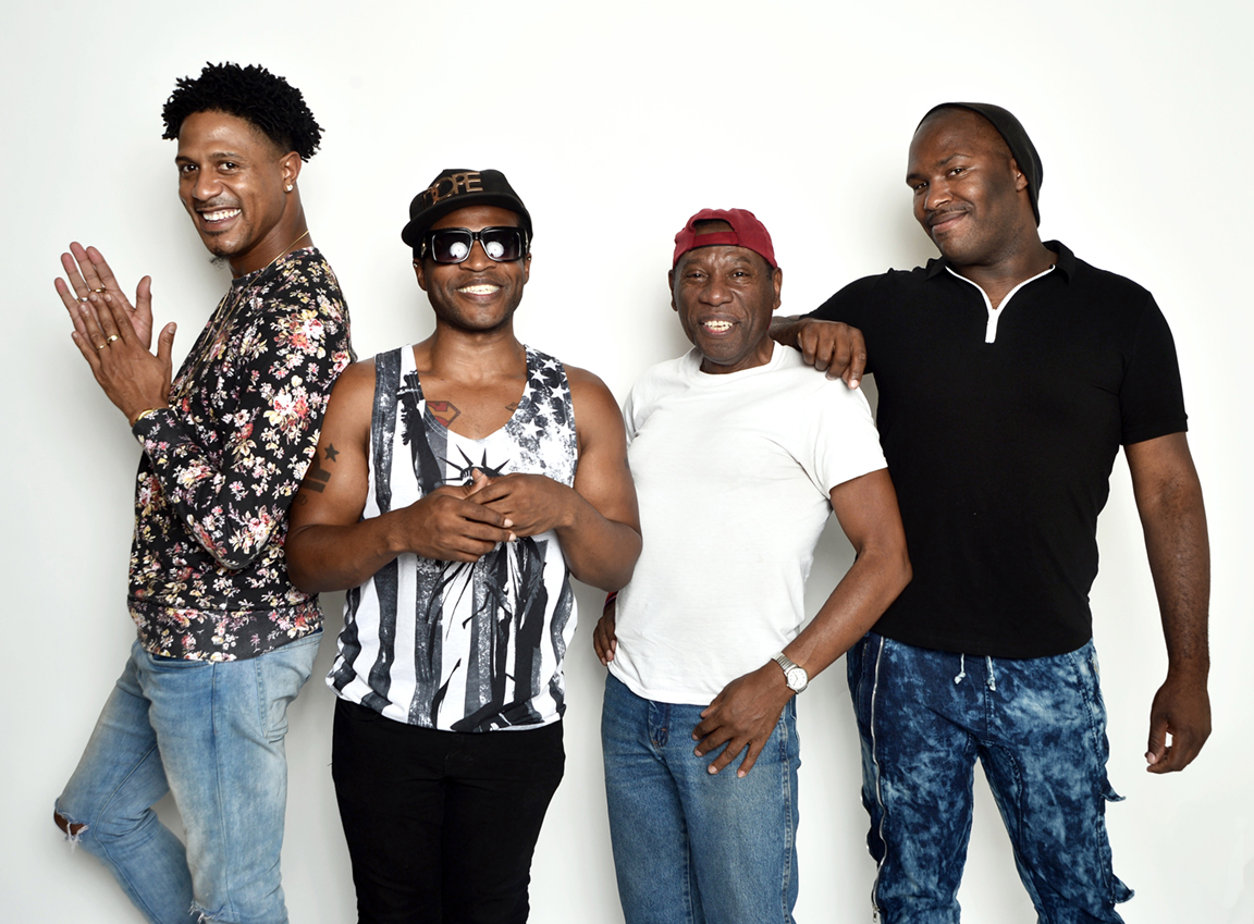 Four cheerful gay Black men posing for a photoshoot