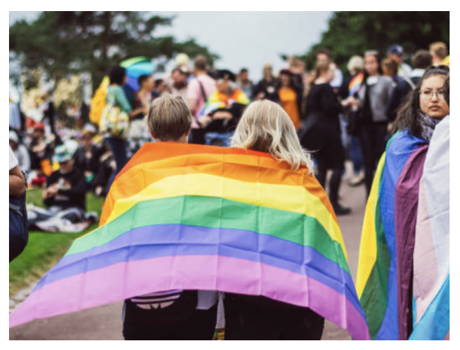 two people wrapped in a rainbow flag